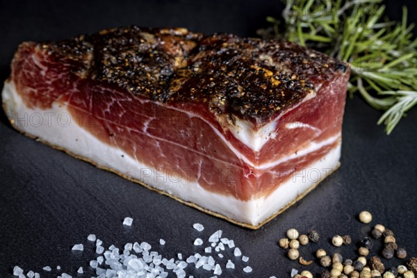 Ham bacon piece on slate plate with salt and peppercorns, delicacy ham fresh from the butcher