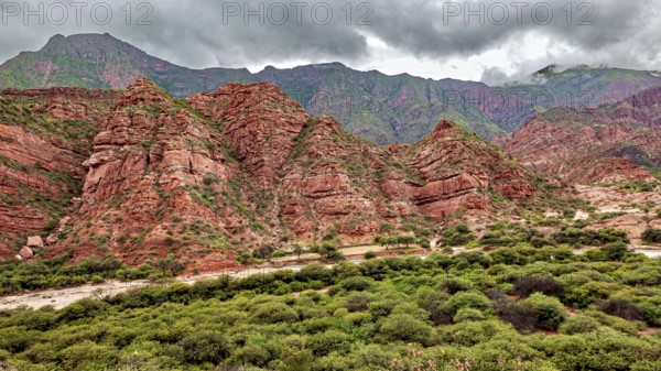 Wild, mountainous landscape with red rocks and thick clouds, The landscape and colorful rock formations of the Quebrada de Cafayate near Salta in Argentina
