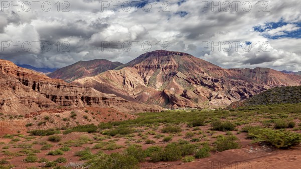 Wide mountain landscape with rock walls and clouds in the sky, the landscape and colorful rock formations of the Quebrada de Cafayate near Salta in Argentina