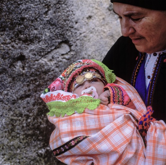 Easter Sunday, grandmother holding little girl in festive traditional dress, Olymbos, Karpathos, Dodecanese, Greece