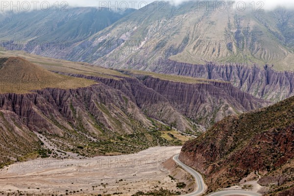 Deep valley with steep slopes in a bare and dry desert landscape, the landscape and colorful rock formations of the Quebrada de Cafayate near Salta in Argentina