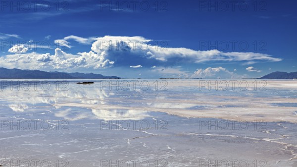 Wide view of a salt lake with cloud reflections in the water, The Salar de Cauchari salt pan near Salta in Argentina