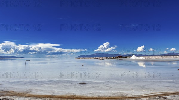 Wide view of a salt lake with blue sky and few clouds, The Salar de Cauchari salt pan near Salta in Argentina