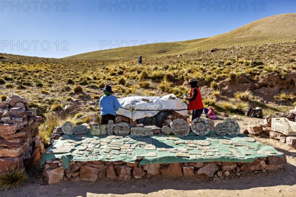 Archaeological excavation in the Andes with handicrafts and stones, surrounded by hills under blue skies, souvenir shop at the Cuesta de Lipán pass in the province of Jujuy in northern Argentina