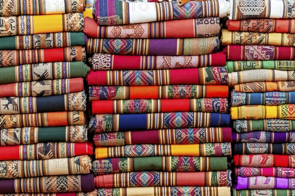 Close-up of stacked, colorful fabrics with traditional patterns, tourist and souvenir market of Santa Rosa de Tastil near Salta in Argentina
