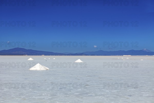 Bright salt landscape with small hills and foothills in the background, clear quiet atmosphere, The Salar de Cauchari salt pan near Salta in Argentina