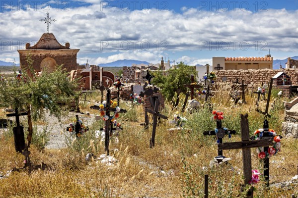Wide cemetery landscape with crosses and hills under a cloudy sky, The Cachi cemetery in Argentina
