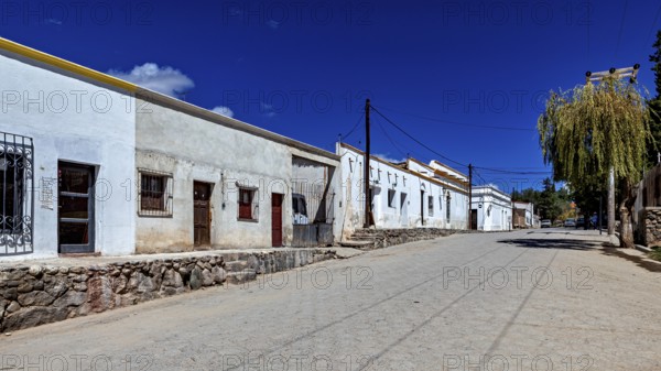 Quiet street with whitewashed houses and deep blue sky on a sunny day, Downtown Cachi in Argentina