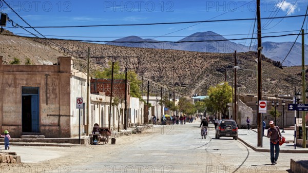 People and vehicles in a small desert town surrounded by rugged hills, San Antonio de los Cobres, Salta Province, Argentina