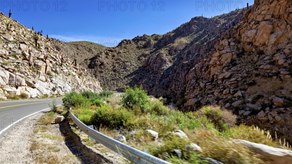 Road winds through rocky gorge in a sunny desert landscape, roads through the Quebrada de Cafayate countryside near Salta in Argentina