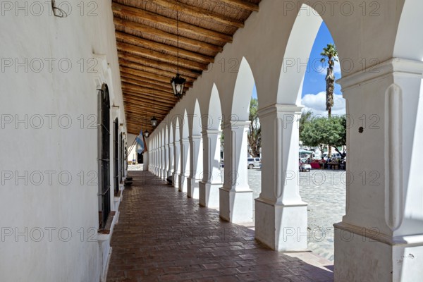 Corridor with arcades and wooden roof, leads outdoors in sunny weather, The arcades of Cachi in Argentina