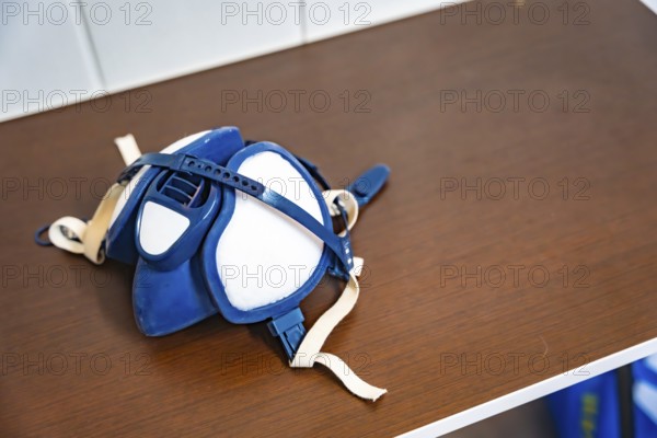Respirator mask on a dusty workbench, highlighting essential ppe for automotive and industrial workshops to protect workers from particulates, fumes and hazardous airborne contaminants