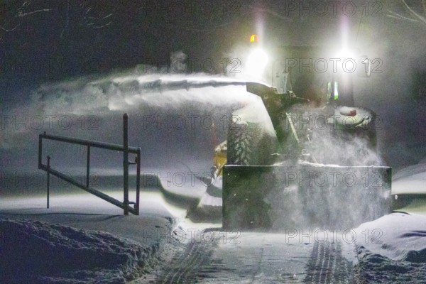 Heavy machinery clearing snow from a property entrance, Region of la Mauricie, Province of Quebec, Canada