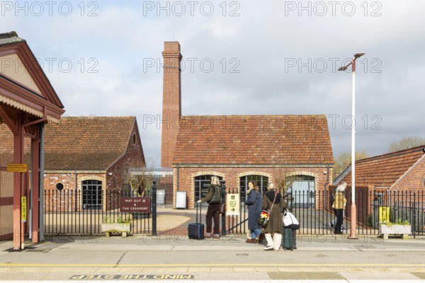 Passengers and buildings at Castle Cary railway station, Castle Cary, Somerset, England, UK