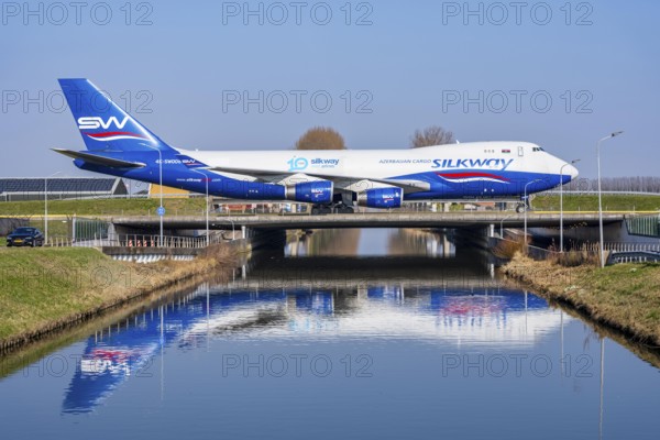 Taxiway bridge over a canal near Hoofddorp, on the Polderbaan, a runway in the west of Amsterdam Schiphol airport, Silkway Boeing 747-4R7F cargo aircraft rolls to the terminal after landing, the Netherlands