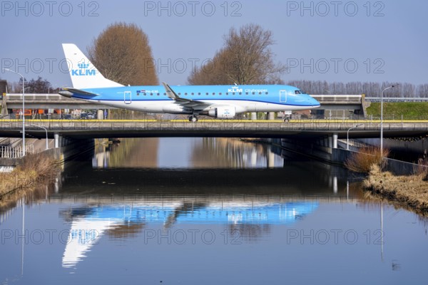 Taxiway bridge over a canal near Hoofddorp, on the Polderbaan, a runway in the west of Amsterdam Schiphol Airport, KLM Embraer E175, aircraft rolls to the terminal after landing, Netherlands