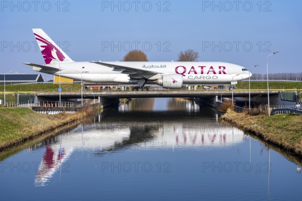 Taxiway bridge over a canal near Hoofddorp, on the Polderbaan, a runway in the west of Amsterdam Schiphol Airport, Qatar Cargo Boeing 777-FDZ, aircraft rolls to the terminal after landing, Netherlands