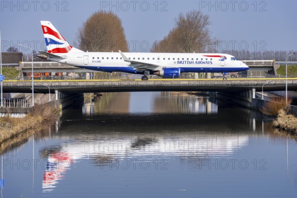 Taxiway bridge over a canal near Hoofddorp, on the Polderbaan, a runway in the west of Amsterdam Schiphol Airport, British Airways Embraer 190, aircraft rolls to the terminal after landing, Netherlands