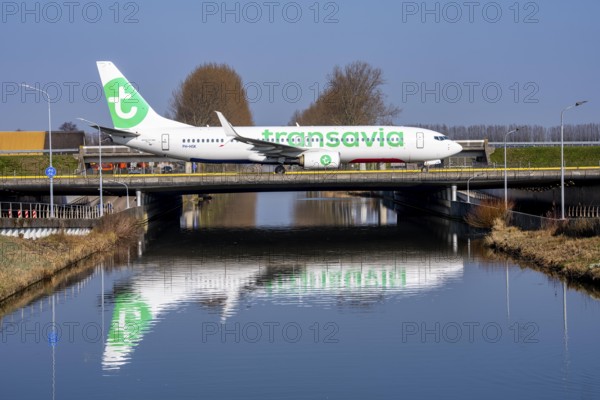 Taxiway bridge over a canal near Hoofddorp, on the Polderbaan, a runway in the west of Amsterdam Schiphol Airport, Transavia Boeing 737-800, aircraft rolls to the terminal after landing, Netherlands