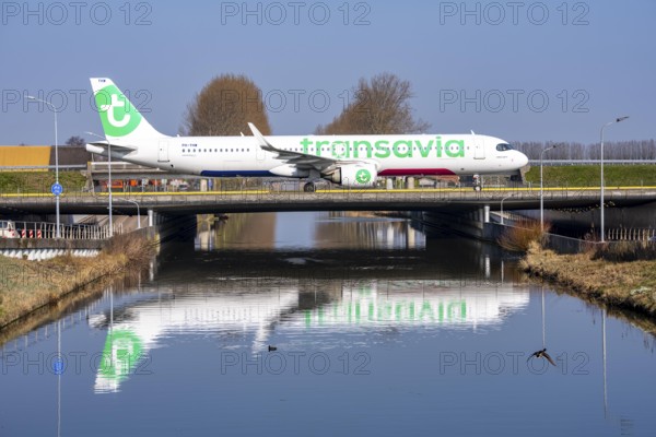 Taxiway bridge over a canal near Hoofddorp, on the Polderbaan, a runway in the west of Amsterdam Schiphol Airport, Transavia Airbus A321-251NX, aircraft rolls to the terminal after landing, Netherlands