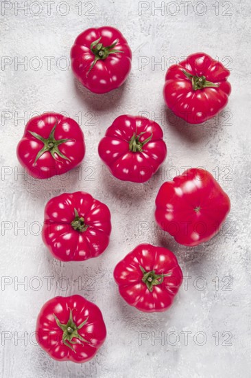 Pink tomatoes scattered on the table, top view, close-up, no people