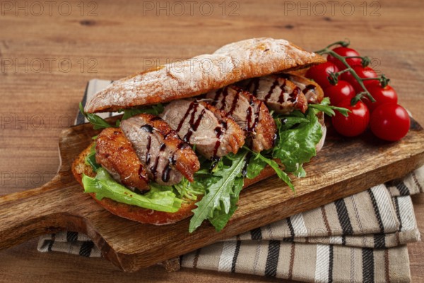 Sandwich with duck breast and arugula, balsamic sauce, on a wooden chopping board, breakfast, homemade, without people