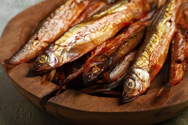 Cold smoked capelin, on a wooden bowl, top view, no people