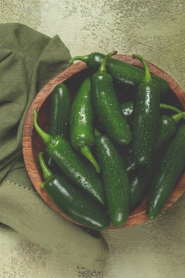 Fresh padron pepper, raw, in a wooden bowl, on the table, there are no people
