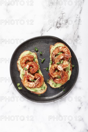 Sandwiches with avocado and caramelized shrimp, micro-greens, breakfast, on a plate, top view, homemade, no people