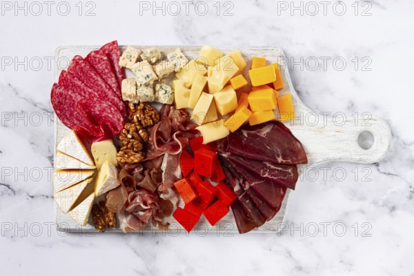 Assortment of cheese meat cuts, on a plate, top view, no people