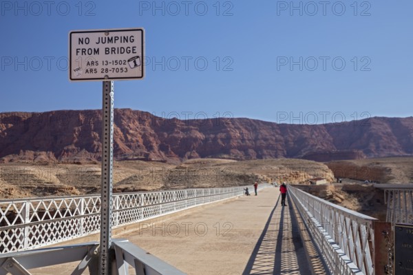 Marble Canyon, Arizona - The historic Navajo Bridge, now a pedestrian bridge, over the Colorado River at the north end of the Grand Canyon. A sign prohibits jumping from the bridge