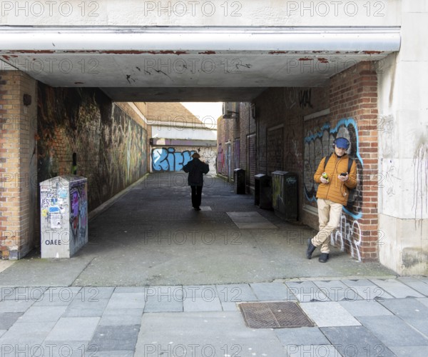 Graffiti sprayed walls in alleyway street in city centre of Plymouth, Devon, England, UK