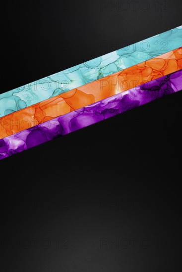 Vibrant diagonal colors inks stripes of teal, orange, and purple on a dark background. This abstract design is ideal for modern art and creative projects