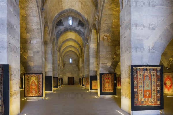 Stony vaulted interior with patterned carpets on display, Sultanhani caravanserai, on the former Silk Road, museum, Sultanhani Kervansaray, Sultanhani, Aksaray province, Turkey