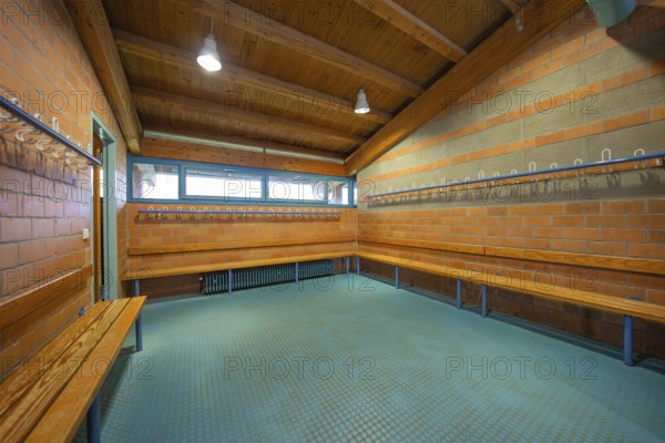 Spacious changing room with wooden ceiling and brick walls as well as benches and bright lamps, Schlehengäu Grund Schule Gechingen, Calw district, Germany