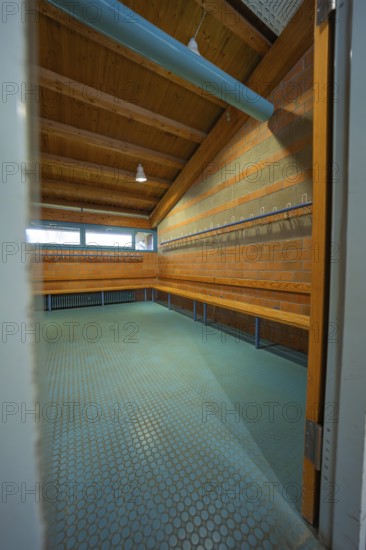 View through an open door into a changing room with brick walls and wooden ceiling, Schlehengäu Grund Schule Gechingen, Calw district, Germany