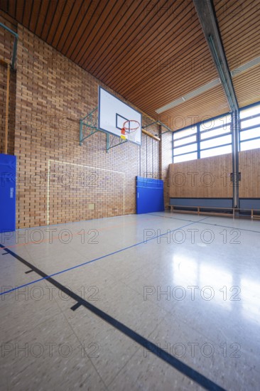 Large sports hall with basketball hoop, wooden walls and brick walls, bright lighting, Schlehengäu Grund Schule Gechingen, Calw district, Germany