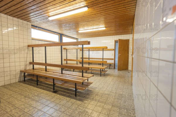 An empty changing room with wooden benches and tiled walls, Schlehengäu Grund Schule Gechingen, Calw district, Germany