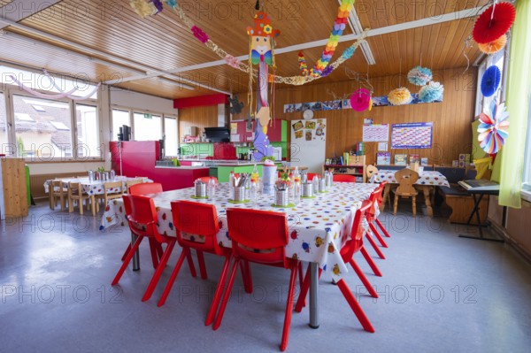 Bright kindergarten room with colorful decorations and red furniture creates a festive atmosphere, Schlehengäu Grund Schule Gechingen, Calw district, Germany