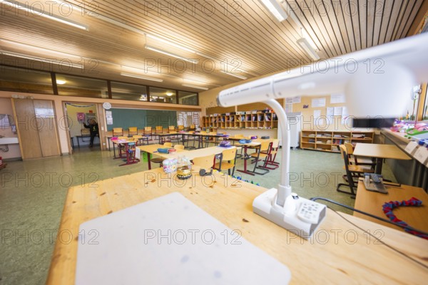 Teacher's desk in a well-lit classroom with blackboards and organized chairs, Schlehengäu Grund Schule Gechingen, Calw district, Germany