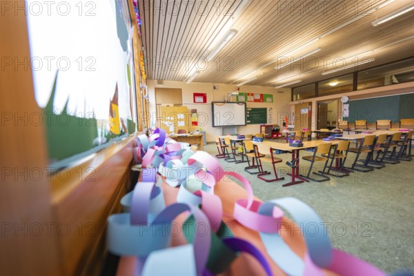 Paper chains hanging in a classroom with a view of windows and rows of seats, Schlehengäu Grund Schule Gechingen, Calw district, Germany