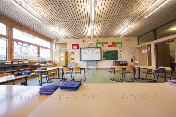 Empty classroom with a view of seating arrangements and blackboards, well-lit through large windows, Schlehengäu Grund Schule Gechingen, Calw district, Germany