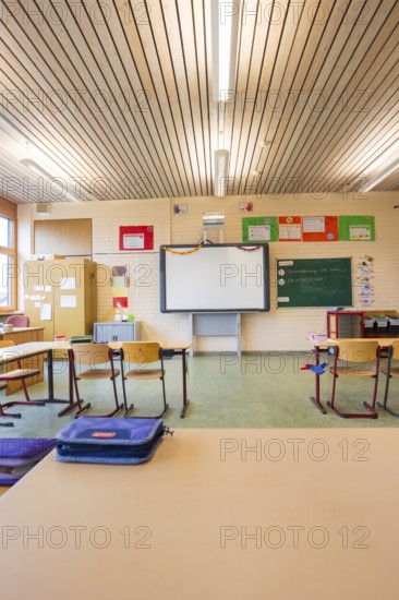 Classroom with wooden furniture and blackboard under an illuminated wooden ceiling, Schlehengäu Grund Schule Gechingen, Calw district, Germany
