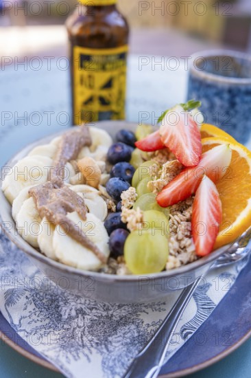 Healthy breakfast with fruit and cereal in a bowl on a table outside, Calw, Calw district, Germany