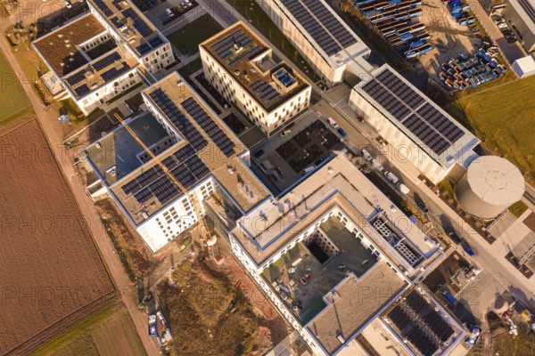 Bird's eye view of building roofs with solar panels and industrial structure, new hospital at Calw Health Campus, Calw district, Germany