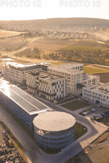 Modern buildings with solar panels in an urban environment surrounded by picturesque fields, new hospital at the Calw health campus, Calw district, Germany