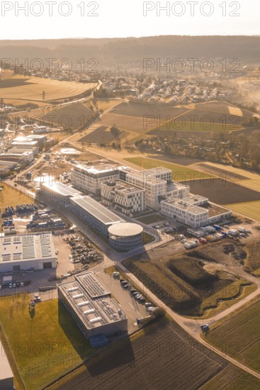 Aerial view of urban landscape in morning light with buildings, parks and fields, new hospital at Calw Health Campus, Calw district, Germany