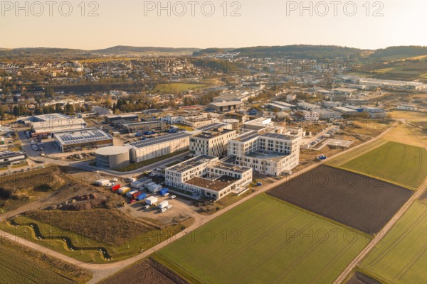Extensive landscape with modern buildings and fields in the light of a clear morning, new hospital at the Calw health campus, Calw district, Germany