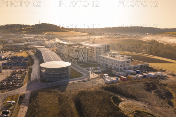 New industrial area with modern buildings and fields in the background at sunrise, new hospital at Calw health campus, Calw district, Germany