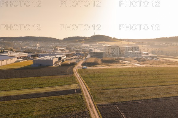 Extensive landscape with fields and buildings captured in low sunlight, new hospital at Calw Health Campus, Calw district, Germany